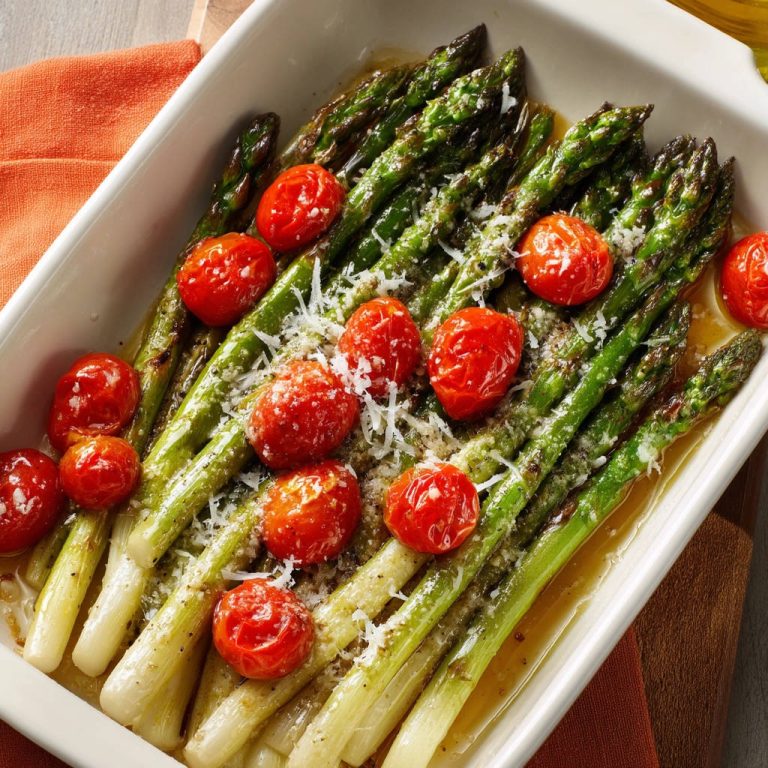 Grüner Ofenspargel mit Tomaten und Parmesan, eine Nahaufnahme der gebackenen Spargelstangen und Kirschtomaten mit geschmolzenem Käse.