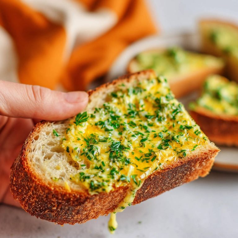 Knoblauchbrot mit perfekt geschmolzenem Käse-Topping und frischer Petersilie, nahaufnahme von einem Stück Brot