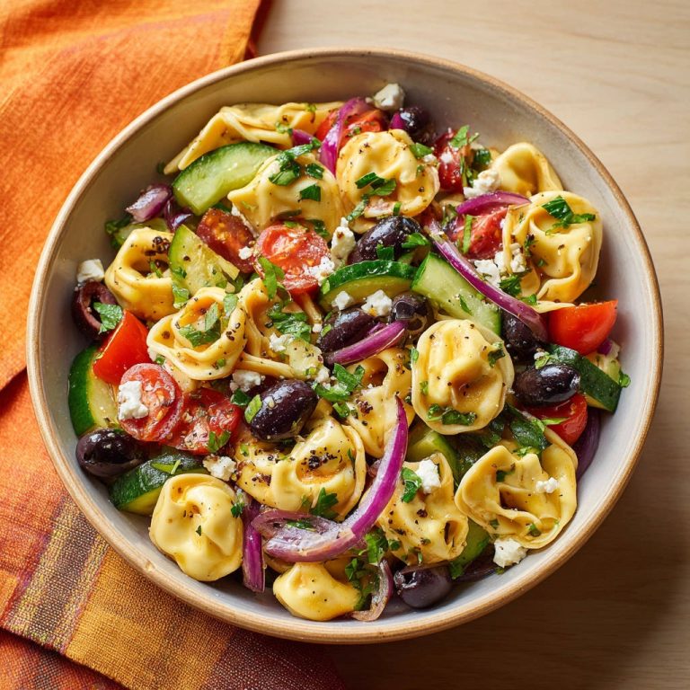 Tortellini-Salat nach griechischer Art in einer Schüssel von oben mit frischen Zutaten und Feta-Käse.