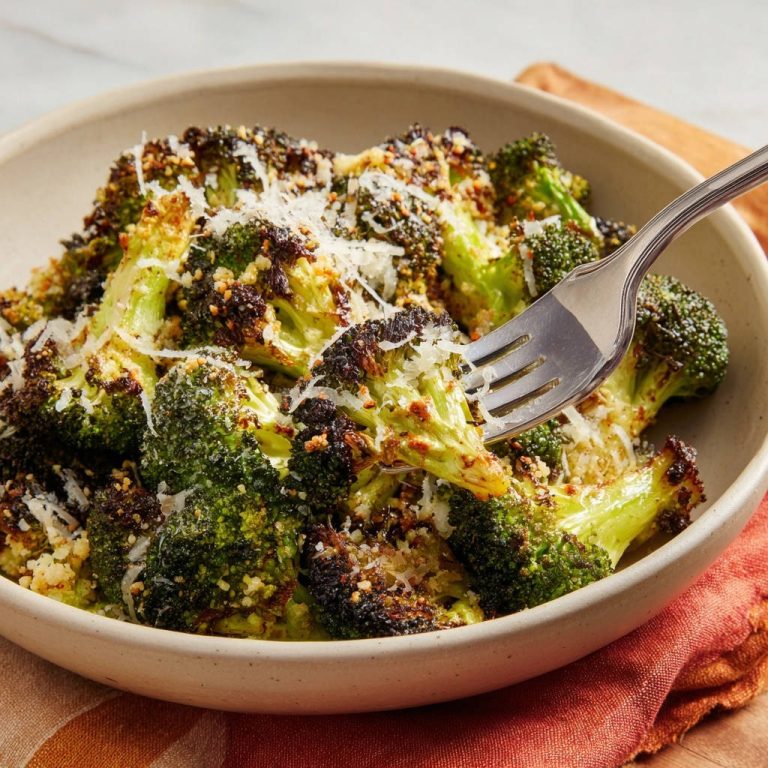Gerösteter Brokkoli mit Parmesan & Knusper-Topping, mit einer Gabel aufgespießt, Nahaufnahme.