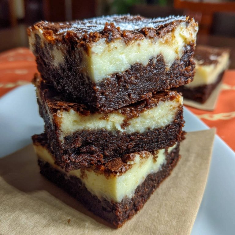 Schoko-Käsekuchen-Brownies: Ein gestapelter Querschnitt zeigt die cremige Käsekuchenschicht über dem saftigen Schokoladenboden.