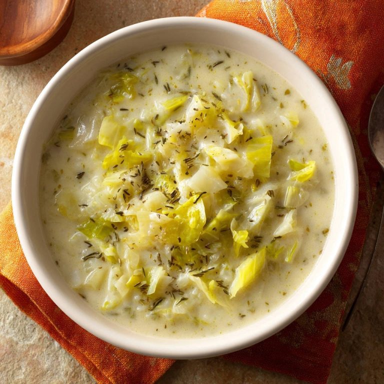 Herzhafte cremige Kohlsuppe mit frischen Kräutern als Nahaufnahme in einer weißen Schüssel.