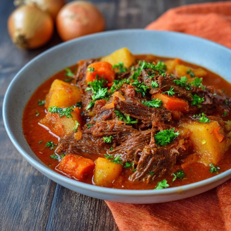 Herzhaftes Rindfleischgulasch mit Kartoffeln als Nahaufnahme mit frischer Petersilie garniert