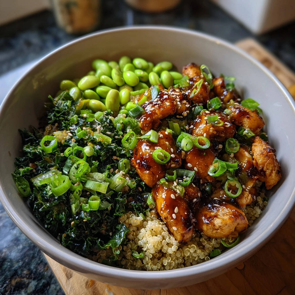 Umami-Hähnchen Bowl mit Quinoa & Grünkohl, garniert mit Frühlingszwiebeln und Sesam, Nahaufnahme der Zutaten.