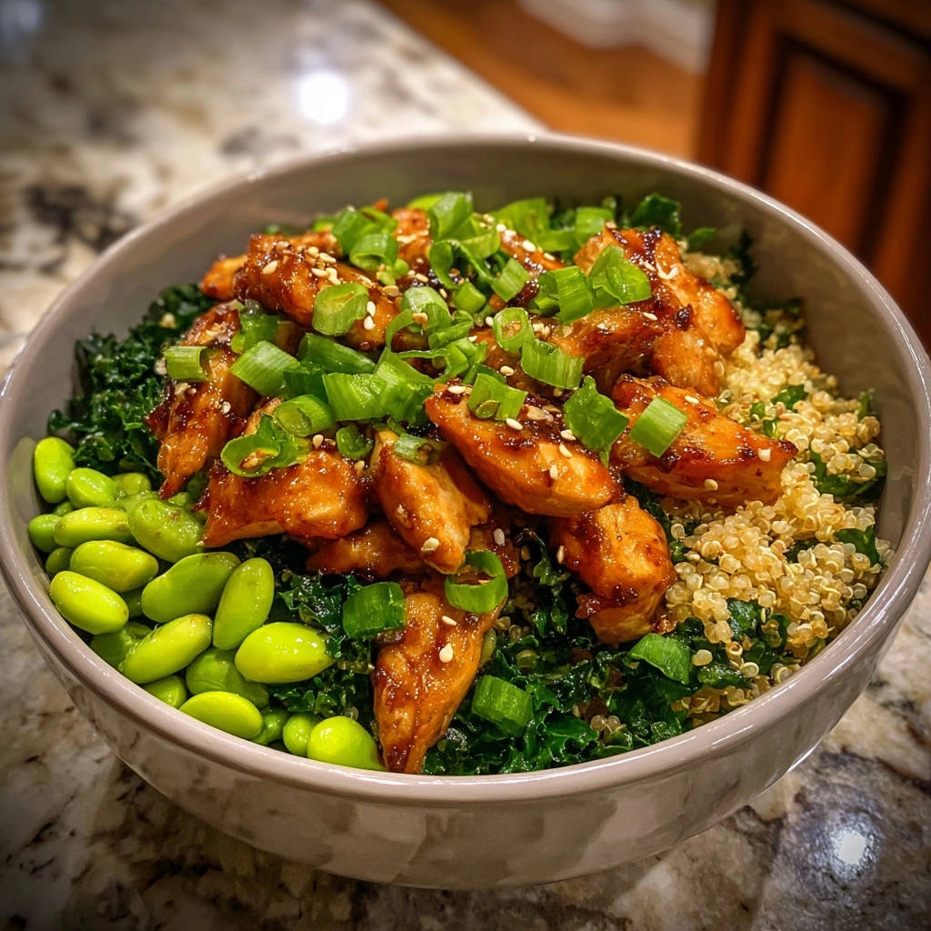 Umami-Hähnchen Bowl mit Quinoa & Grünkohl, garniert mit Frühlingszwiebeln und Sesam, Nahaufnahme der Texturen.