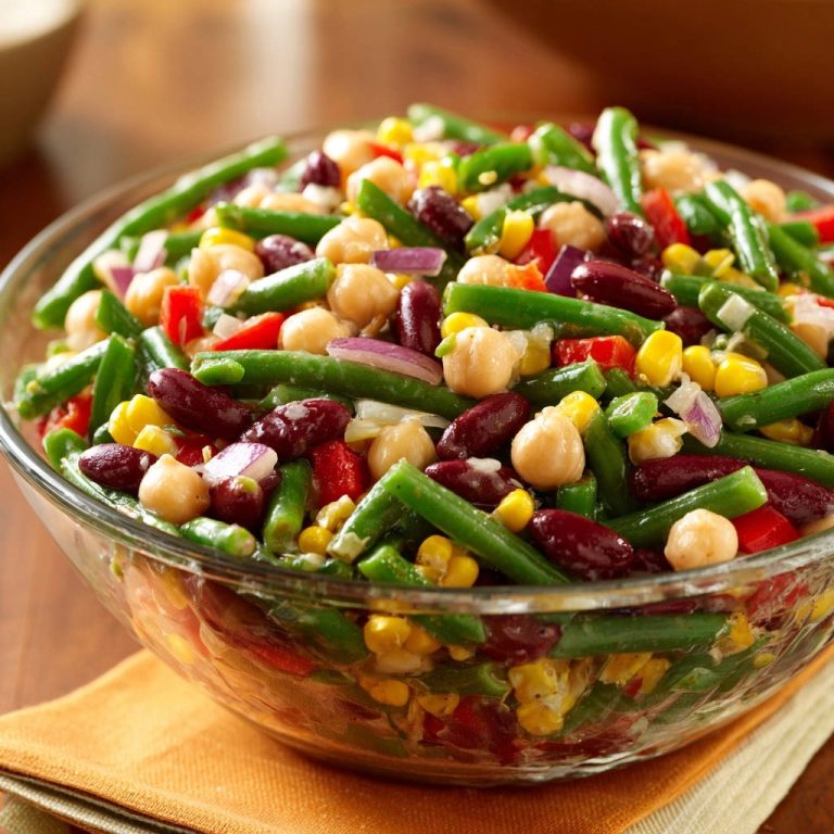 Farbenfroher Power-Bohnensalat in einer Glasschüssel, Nahaufnahme der knackigen Zutaten und roten Zwiebeln