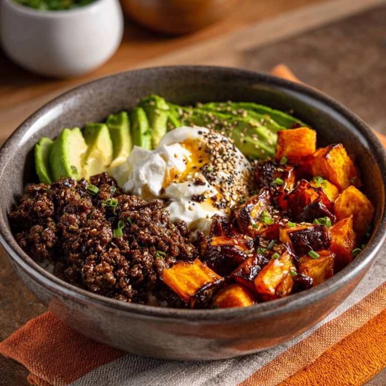 Süßkartoffel-Hackfleisch-Bowl mit Avocado, garniert mit Frühlingszwiebeln und Sesam, im Detail gezeigt.