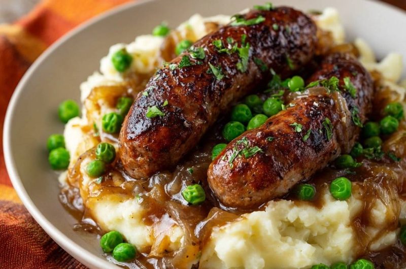 Bratwürste mit Kartoffelbrei, Erbsen und Zwiebelsoße