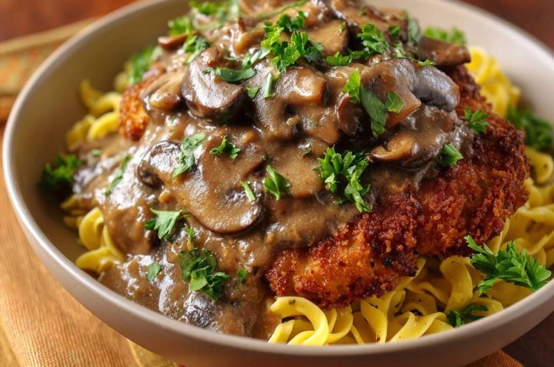 Paniertes Hähnchenschnitzel mit Pilz-Rahm-Soße und Bandnudeln