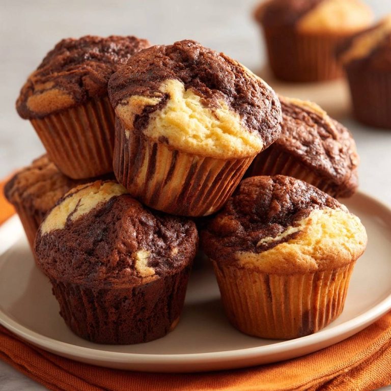 Schoko-Vanille-Marmor-Muffins als Stapel im Fokus auf einem Teller, leicht nah aufgenommen