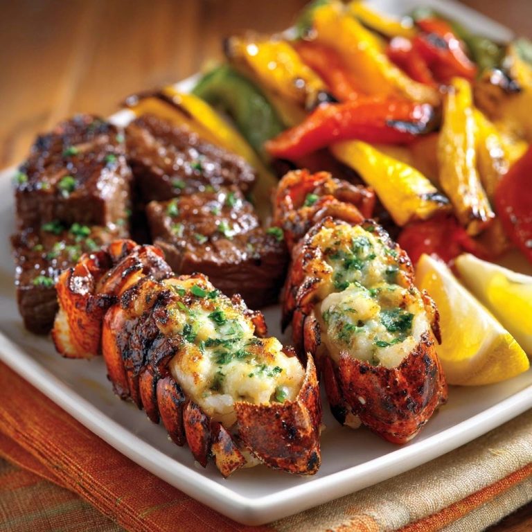 Surf & Turf: Gegrillte Hummerschwänze mit Rindersteak und Paprika, nahaufnahme mit Garnitur aus Kräutern