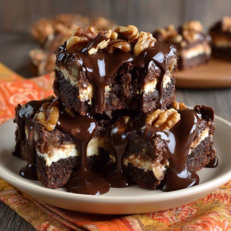 Walnuss-Cheesecake-Brownies mit Schokoguss, detailreiche Nahaufnahme des geschmolzenen Schokogusses und Walnüssen.