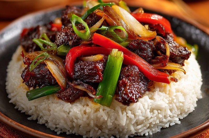 Saftiges Rindfleisch mit Paprika und Zwiebeln auf Reis