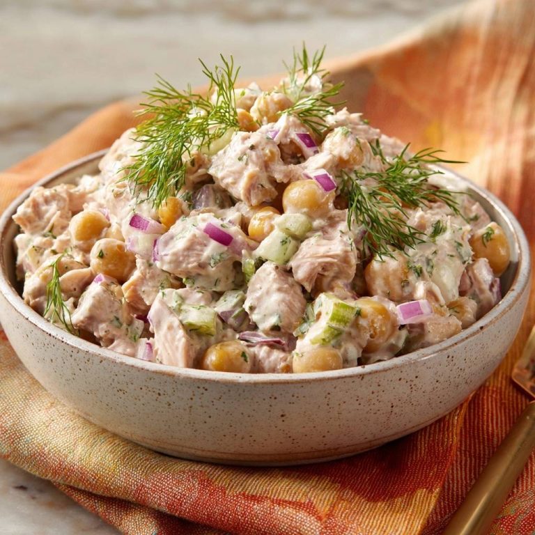 Cremiger Thunfisch-Kichererbsen-Salat in einer Schüssel, garniert mit Dill und roten Zwiebeln, Nahaufnahme.