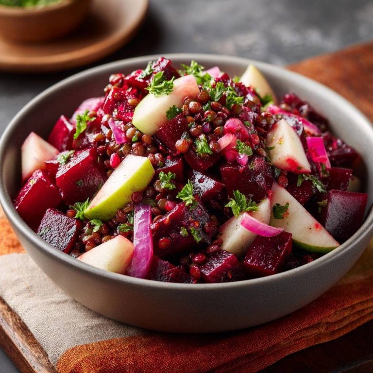 Knackiger Rote-Bete-Linsen-Salat mit Apfel und Granatapfel, Nahaufnahme in einer Schüssel mit frischer Petersilie garniert.