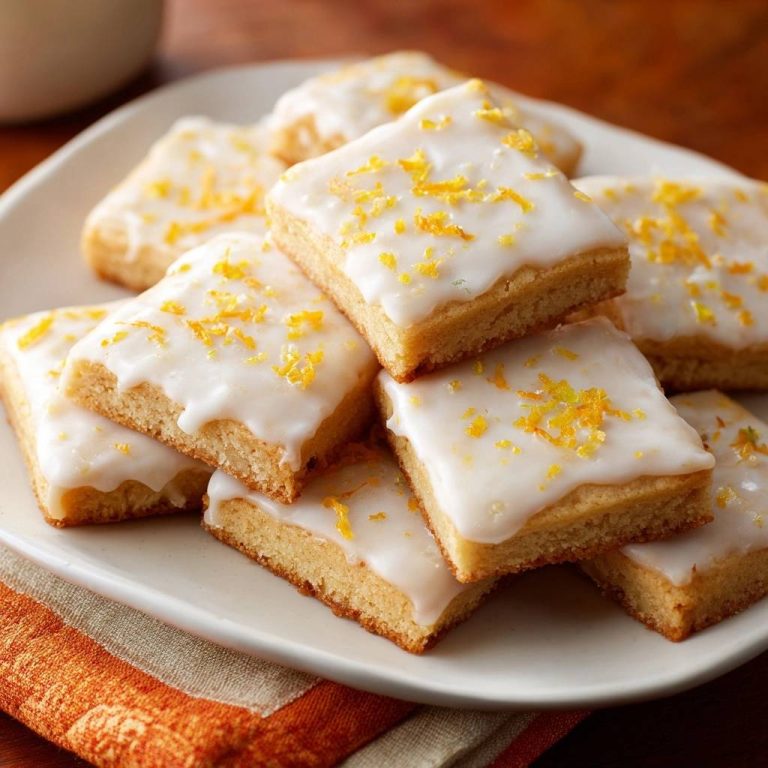 Zitronen-Brownies, garniert mit Zitronenschale, gestapelt auf einem Teller in Nahaufnahme