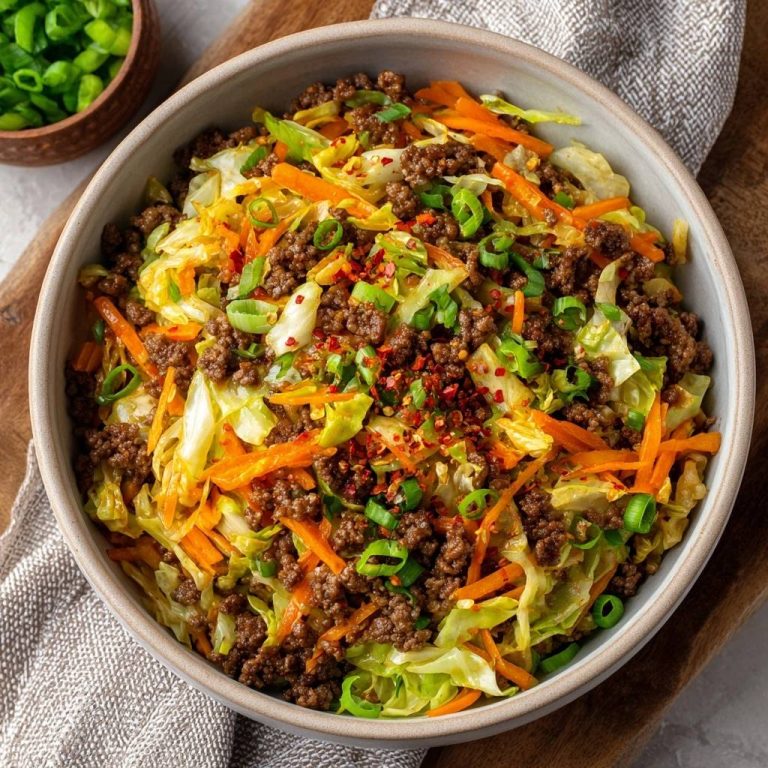 Asiatischer Rinderhack-Wok mit Chinakohl, serviert in einer Schüssel mit Frühlingszwiebeln und Chili-Flocken, von oben gesehen.