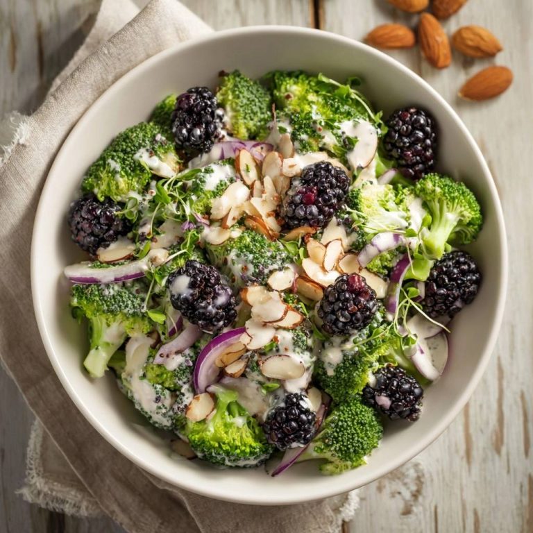 Frischer Brokkoli-Brombeer-Salat in einer Schüssel von oben mit Brombeeren, Mandeln und einer cremigen Sauce.