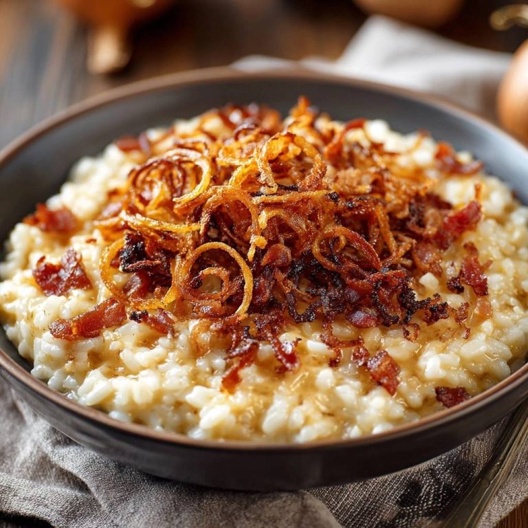 Cremiges Risotto mit knusprigem Speck und Zwiebeln, serviert in einer Schüssel, Nahaufnahme der Textur und Toppings.