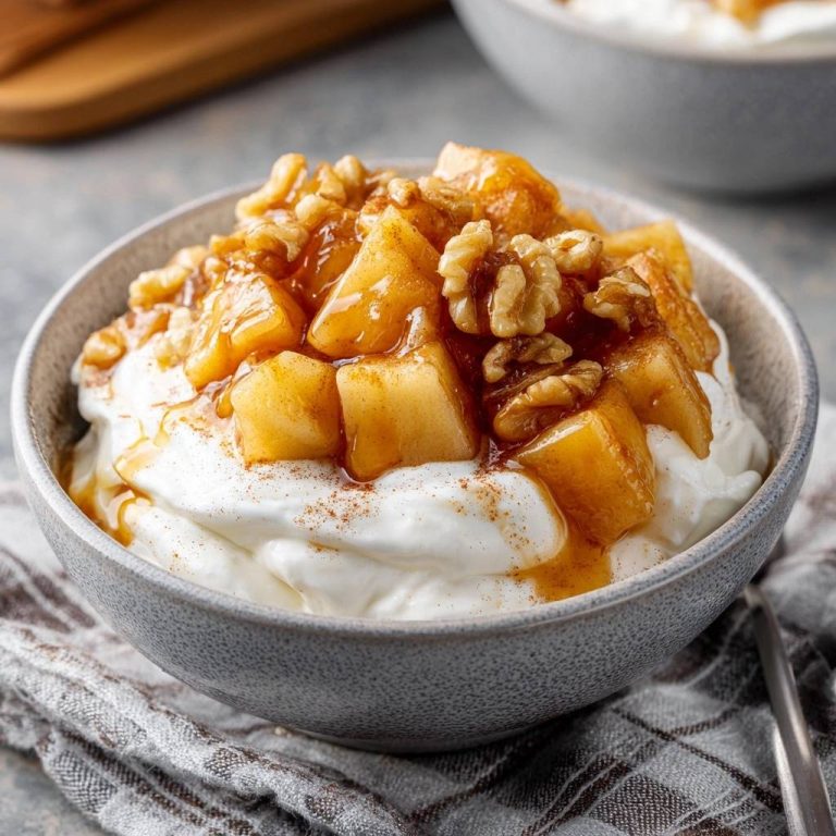 Karamellisierte Apfel-Walnuss-Joghurt mit Zimt und Nüssen, als Nahaufnahme des Toppings in einer Schüssel.