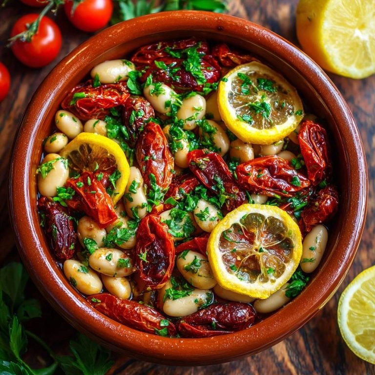 Mediterraner Weißbohnensalat mit Tomaten & Zitrone, von oben in einer braunen Schüssel mit frischer Petersilie und Zitronenscheiben garniert.