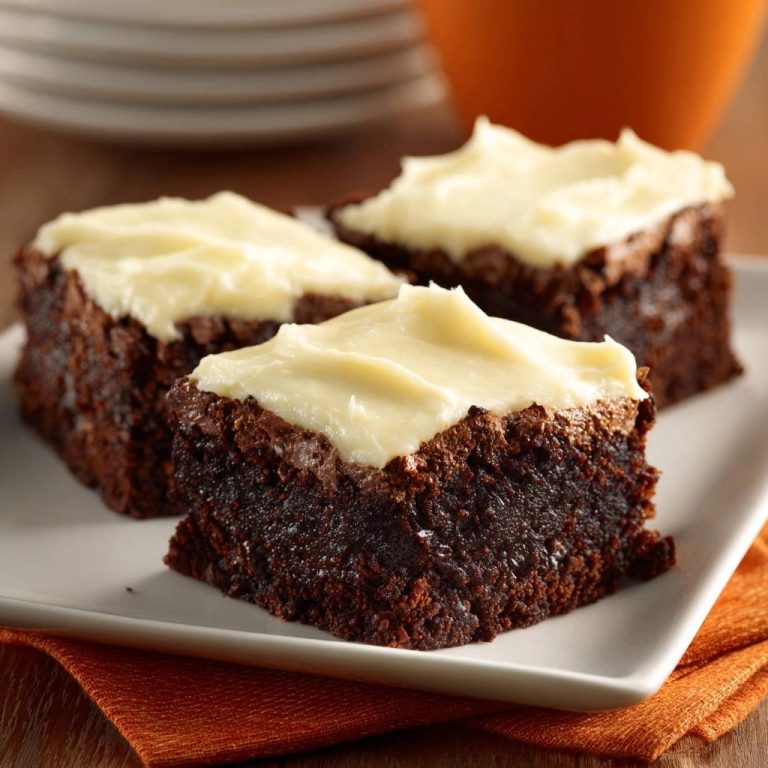 Saftige Schokoladen-Brownies mit Vanille-Frosting als Nahaufnahme von drei Stück auf einem Teller serviert.