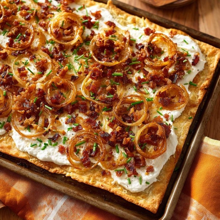 Knuspriger Speck-Zwiebel-Flammkuchen mit frischen Kräutern und Ringen aus karamellisierten Zwiebeln, nahaufnahme.