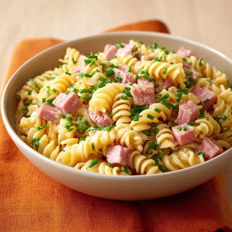Cremige Schinken-Nudeln mit Schnittlauch, angerichtet in einer Schüssel und garniert mit frischem Schnittlauch.