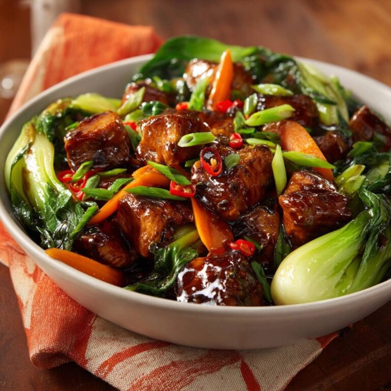 Glasierte Rindfleisch-Wokpfanne mit Pak Choi in Schüssel mit Nahaufnahme der glänzenden Fleischstücke und knackigem Gemüse.