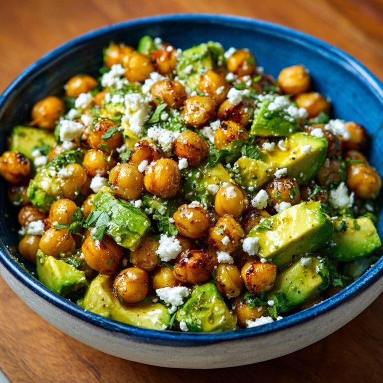 Mediterraner Kichererbsen-Avocado-Salat als Nahaufnahme mit zerbröseltem Feta und frischer Petersilie garniert.
