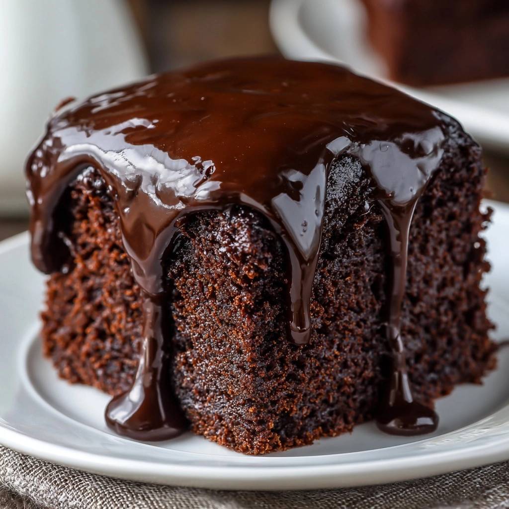 Saftiger Schokoladen-Fudge-Kuchen mit reichhaltiger Schokoladenglasur, die an der Seite heruntertropft.