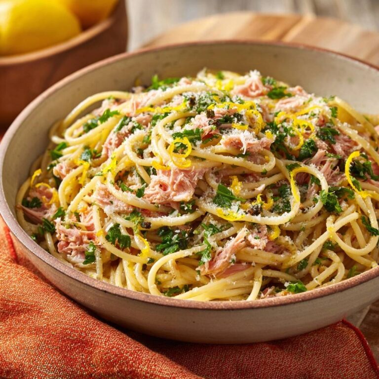 Zitronen-Pasta mit Thunfisch, garniert mit Zitronenzesten, Petersilie und geriebenem Parmesan in einer Schüssel.